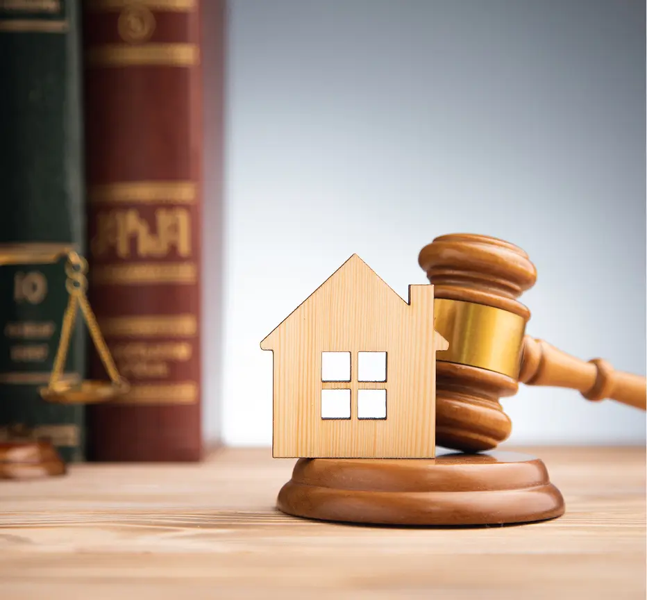 Gavel striking near miniature home.