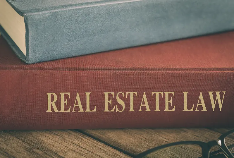 Real estate law book on wooden desk.